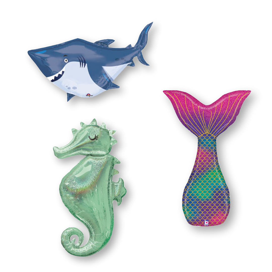Three mylar sea creature balloons, including a smiling shark, a sea horse, and a mermaid tail