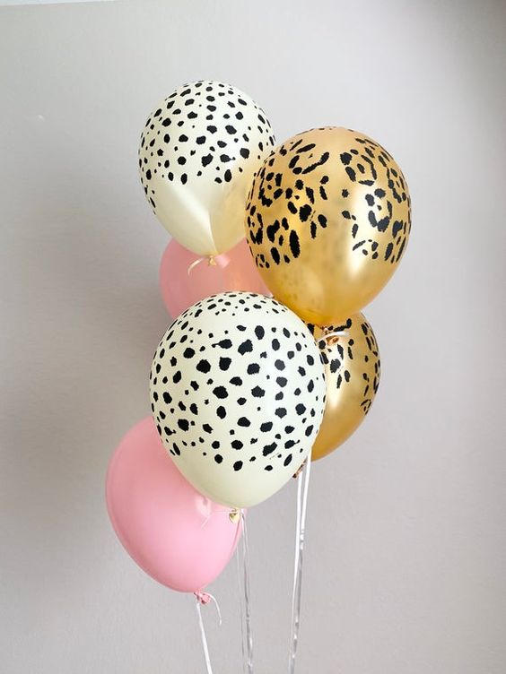 Small bouquet of safari themed latex balloons set against a white wall backdrop.